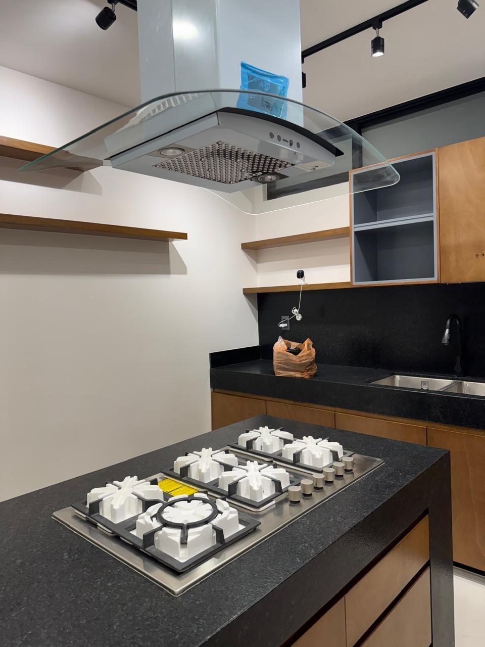 Cocina con alacena de madera y cubierta de granito