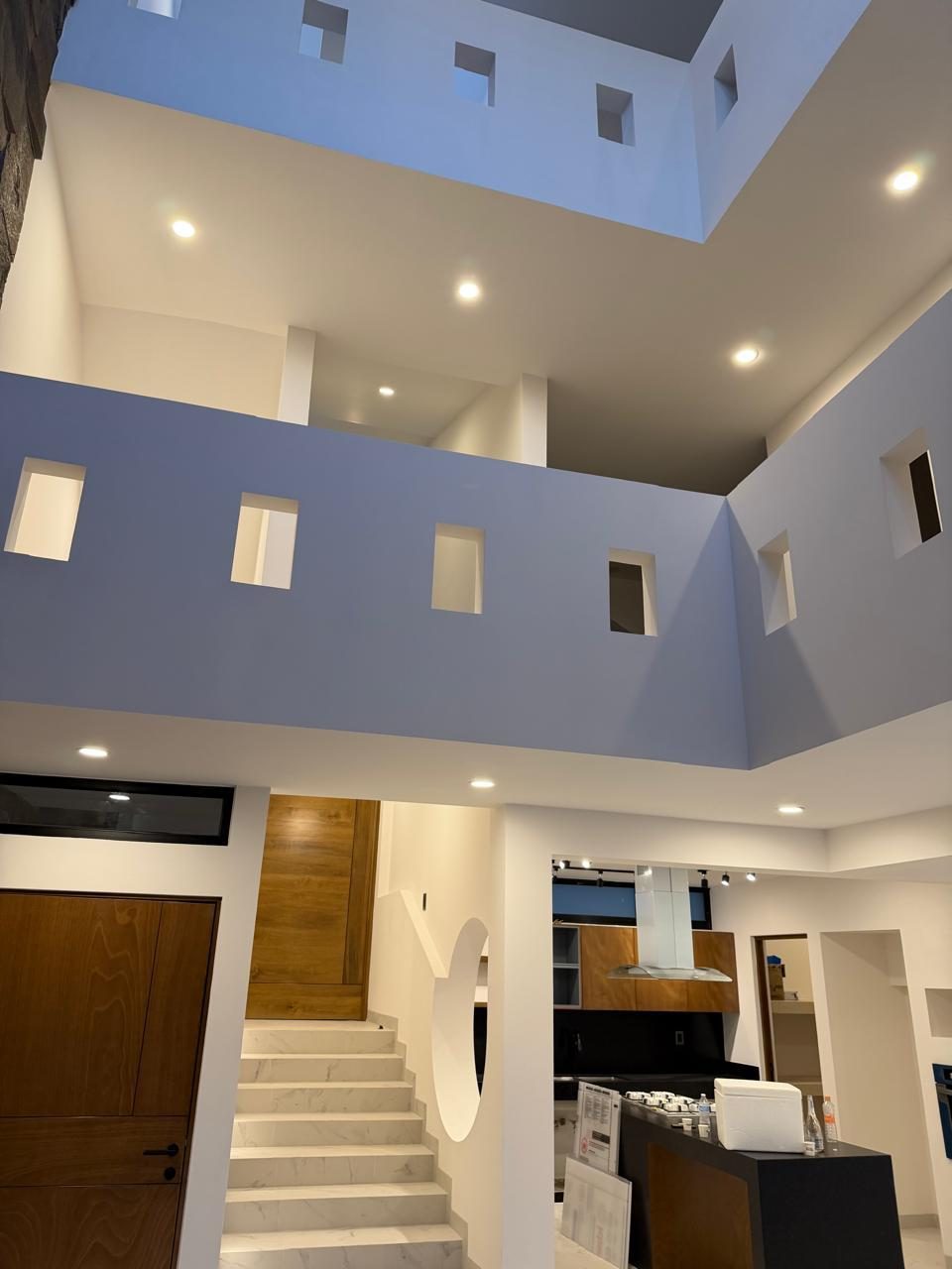 Sala con doble y triple altura hacia la escalera
